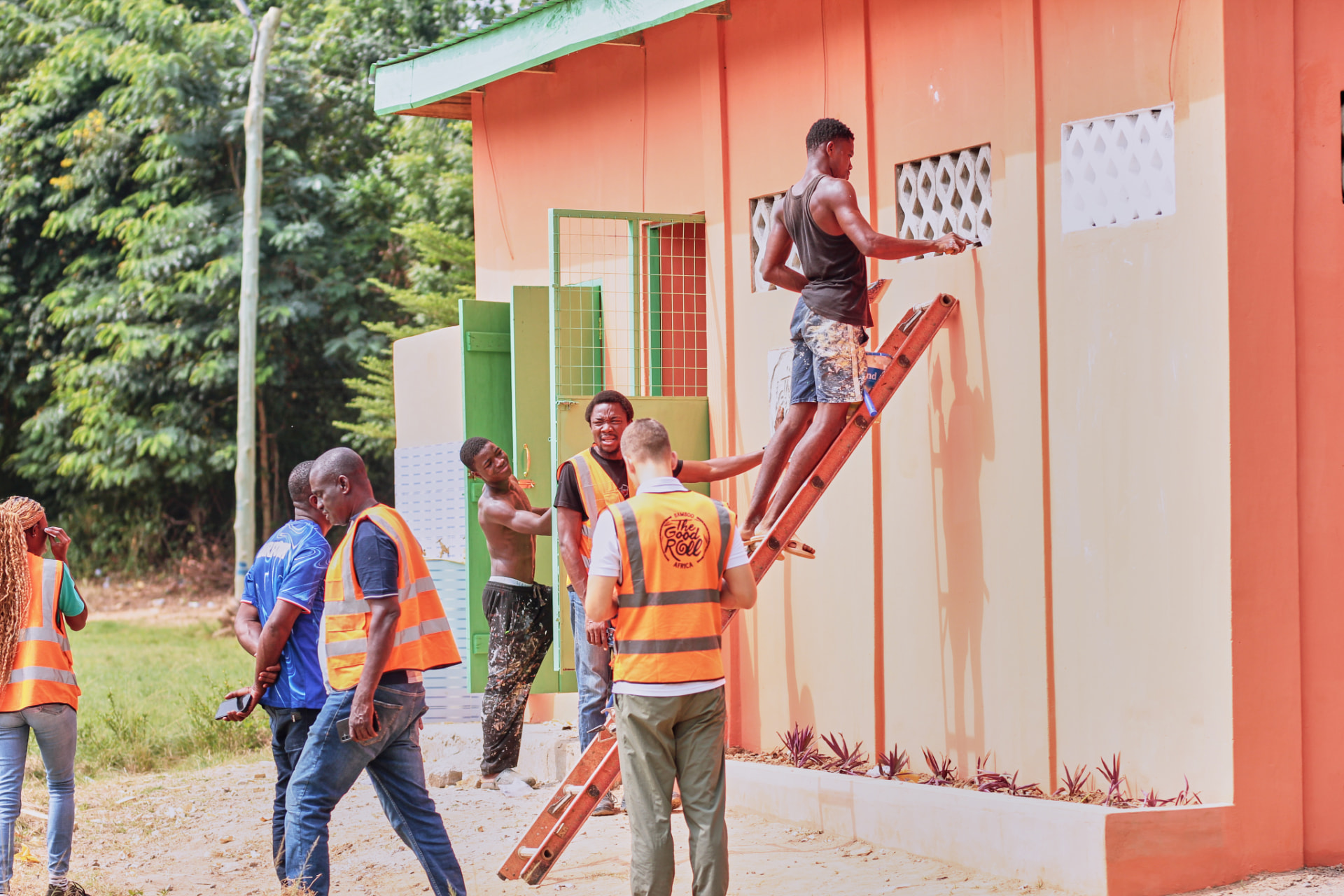 The team paints and finishes the outside of a new toilet block with green doors and vent screens